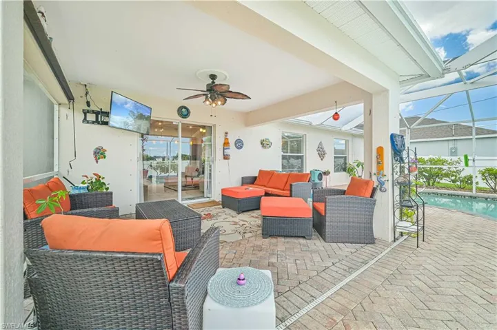 View of patio / terrace featuring ceiling fan, an outdoor living space, and glass enclosure