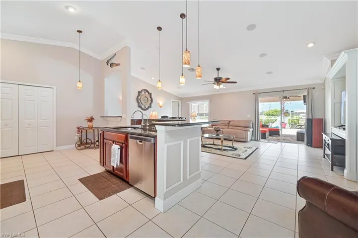 Kitchen with ceiling fan, hanging light fixtures, light tile patterned flooring, and dishwasher