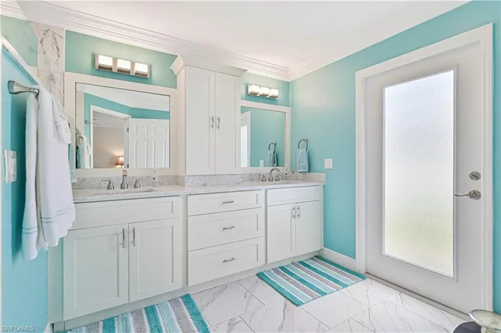 Bathroom featuring tile patterned flooring, vanity, and ornamental molding