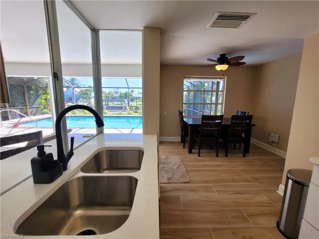 Kitchen sink with stainless steel double basin, matte black faucet, and white countertop