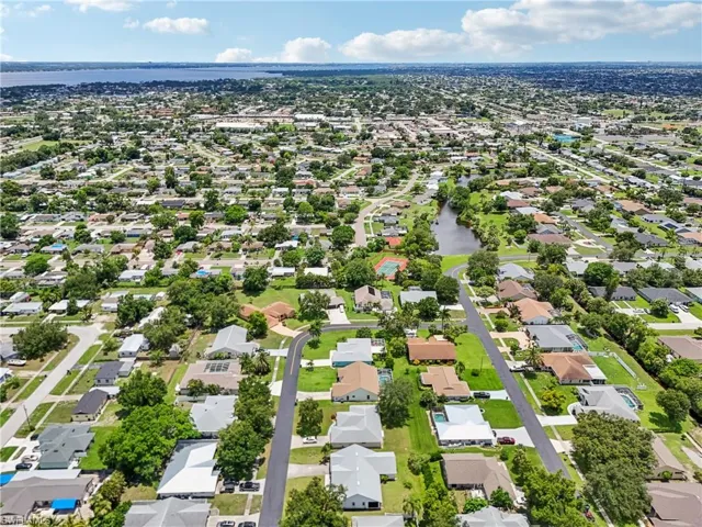 Aerial perspective of suburban area featuring a nearby body of water