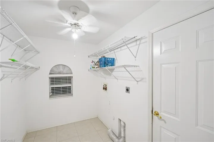 Laundry area featuring hookup for an electric dryer, ceiling fan, washer hookup, and light tile patterned floors