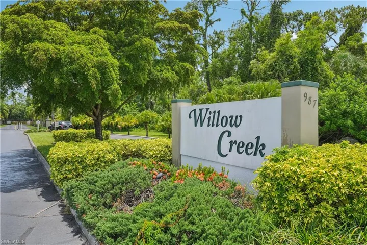 Community sign with view of scattered trees