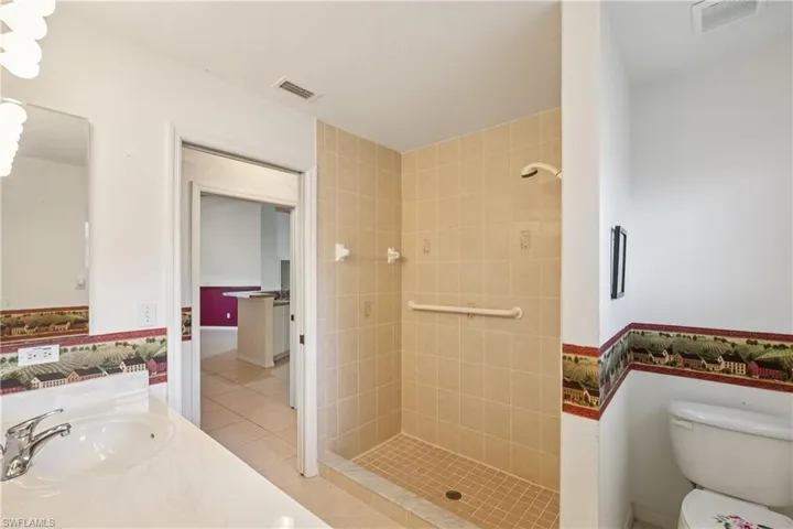 Guest full bath with a shower stall, vanity, and tile patterned flooring