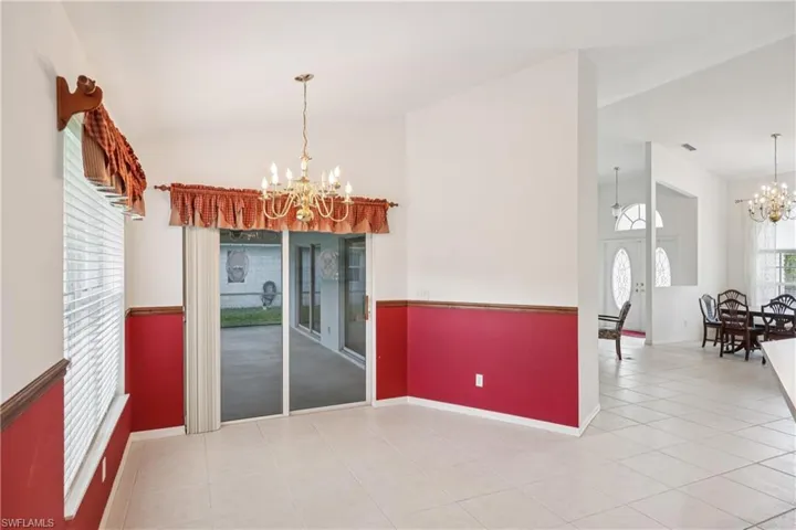 Tiled dining space with a chandelier and baseboards