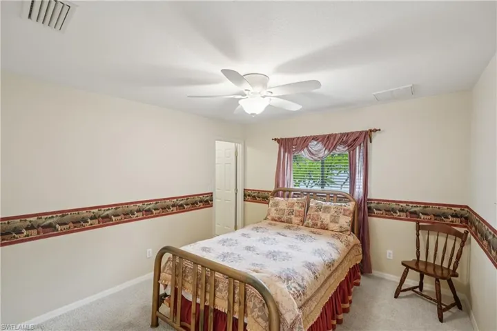 Guest bedroom 2 featuring light carpet and a ceiling fan