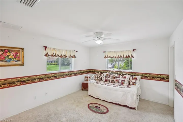 Guest bedroom 3 with multiple windows and ceiling fan