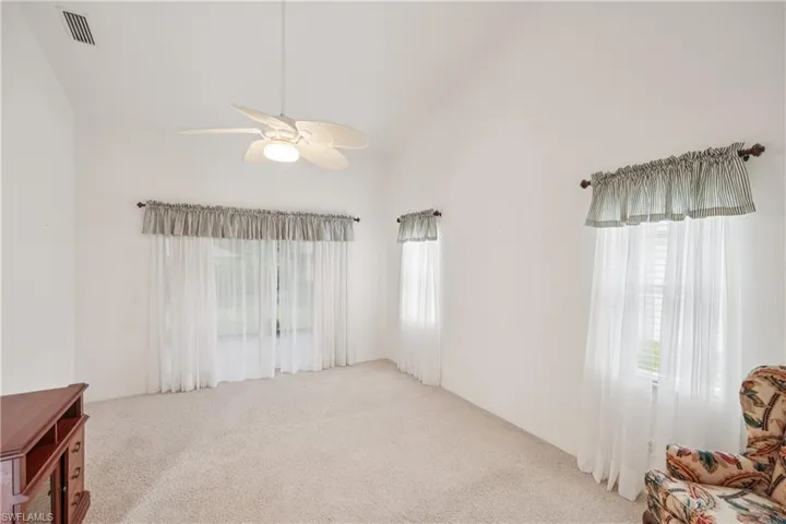 natural light, ceiling fan, and lofted ceiling