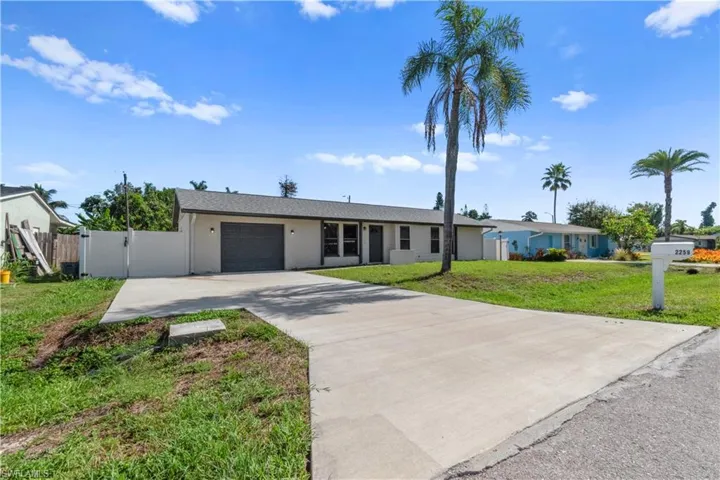 Single-story residence featuring a gray exterior, attached garage with a dark gray door, and a concrete driveway