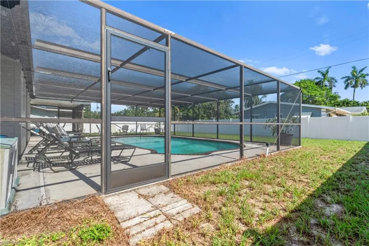 Screened-in swimming pool enclosure featuring a concrete deck and a perimeter fence