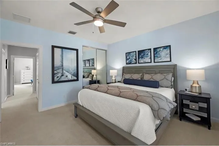 Bedroom featuring light blue walls, carpeted flooring, and a ceiling fan with integrated lighting
