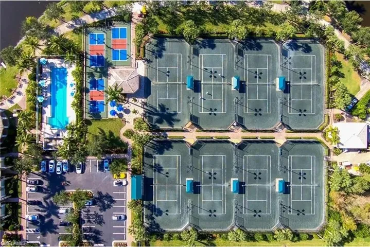 Aerial view showcasing numerous tennis courts, a swimming pool, and dedicated pickleball courts