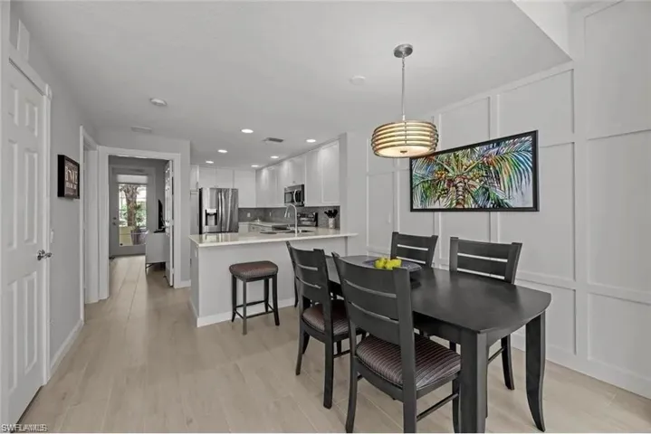 The property features an open-concept layout with light-colored flooring, white walls, and recessed lighting