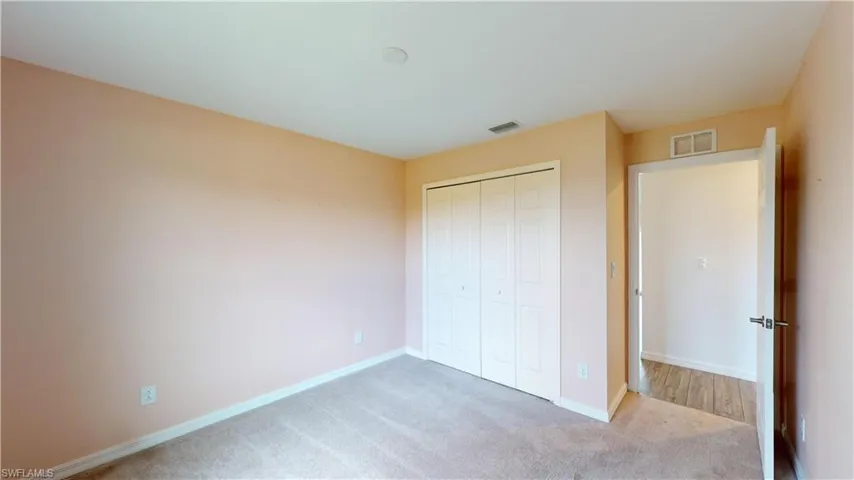 Unfurnished bedroom with a closet and carpet