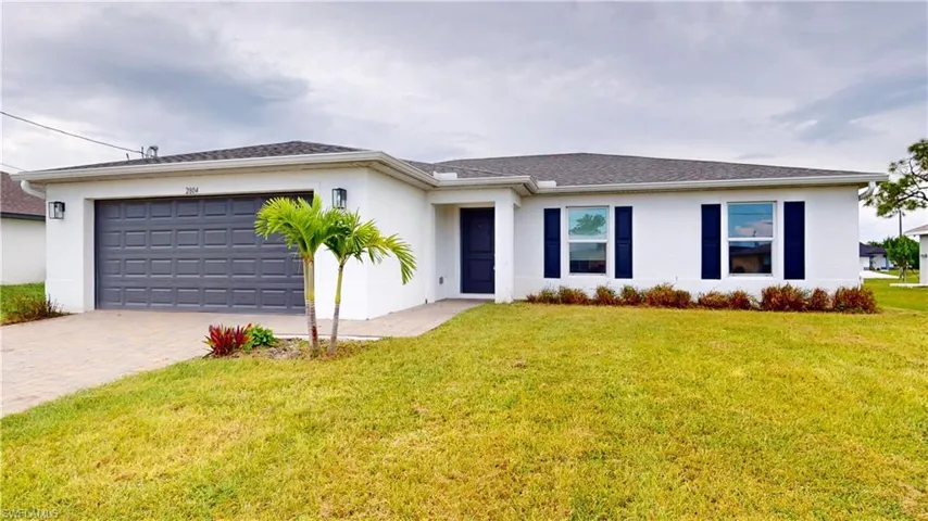 Single story home featuring a front yard and a garage