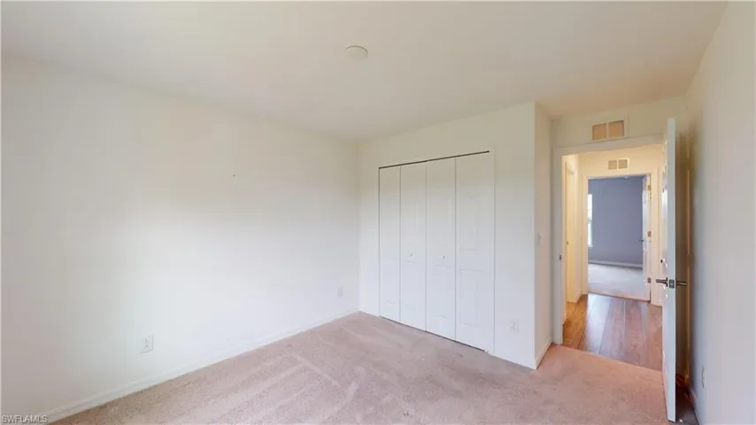 Unfurnished bedroom featuring carpet and a closet