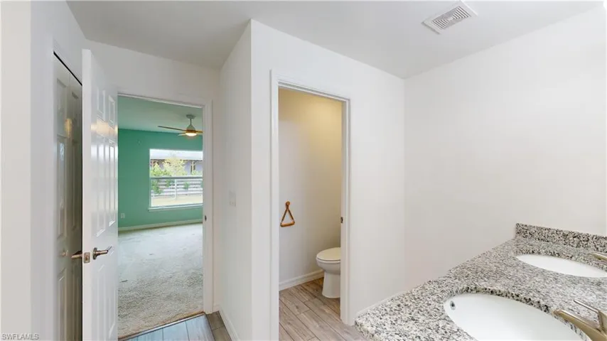 Bathroom with vanity, toilet, hardwood / wood-style floors, and ceiling fan