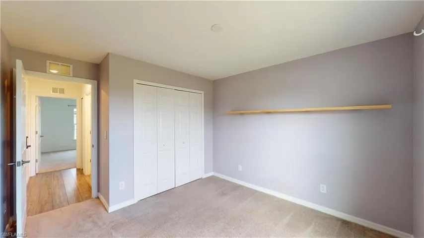 Unfurnished bedroom with a closet and carpet flooring