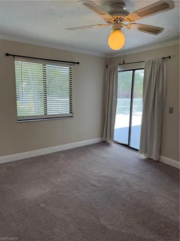 Unfurnished room featuring crown molding, a ceiling fan, and light colored carpet