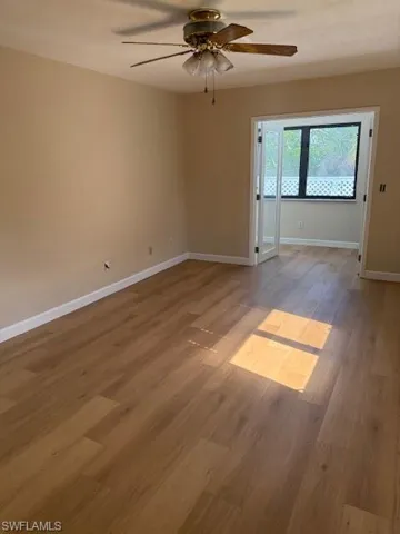 Empty room featuring light wood-style flooring and ceiling fan