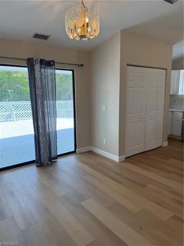 Unfurnished dining area featuring light wood finished floors and a chandelier