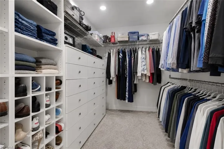 Custom closet system featuring extensive shelving, built-in drawer units, shoe cubbies, and multiple hanging rods