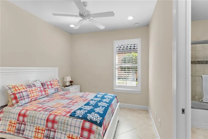 Bedroom with light tile patterned floors, ceiling fan, and recessed lighting