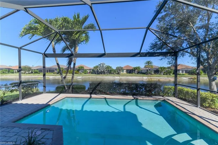 Swimming pool with a sunroom, glass enclosure, and a residential view