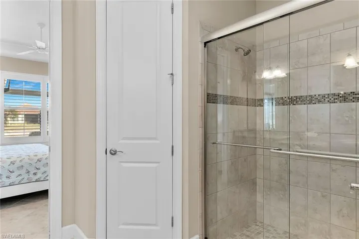 Bathroom featuring ensuite bathroom, a stall shower, and ceiling fan