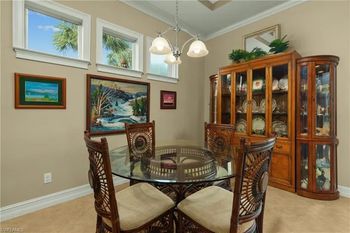 Tiled dining space with a chandelier and ornamental molding