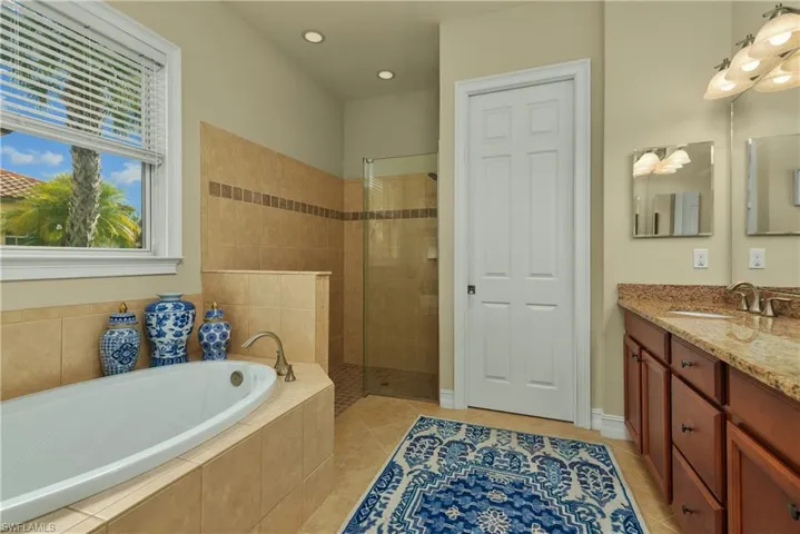 Bathroom with tile patterned flooring, vanity, and independent shower and bath