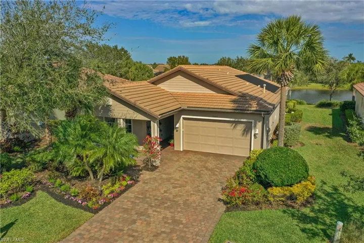 Ranch-style home featuring a water view, a front yard, and a garage
