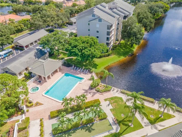 View of community poo, bocce and shuffleboard courts overlooking lake
