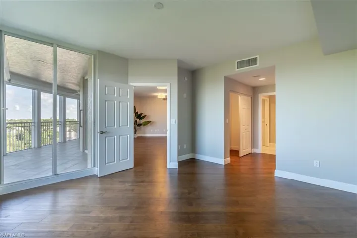 Primary bedroom hardwood flooring and access to lanai