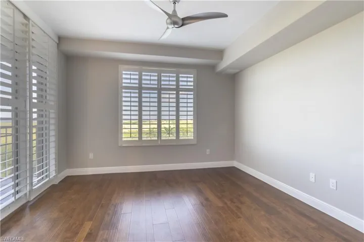 Guest bedroom with plantation shutters, hardwood floors and views overlooking the Gulf