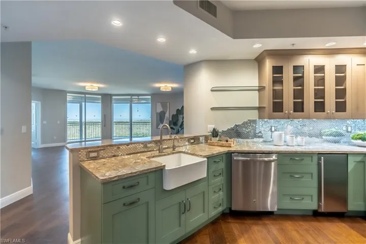 Kitchen with two tone wood uppers and lowers, farmhouse sink and stainless appliances