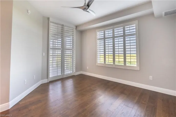 Guest bedroom with access to lanai, plantation shutters and view overlooking the Gulf