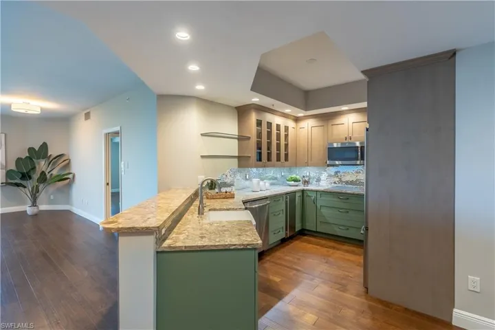 Kitchen featuring upgraded wood cabinets, two tone uppers and lowers, stainless appliances and peninsula
