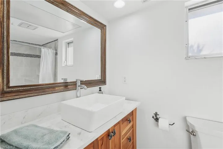 Bathroom featuring vanity, toilet, plenty of natural light, and curtained shower