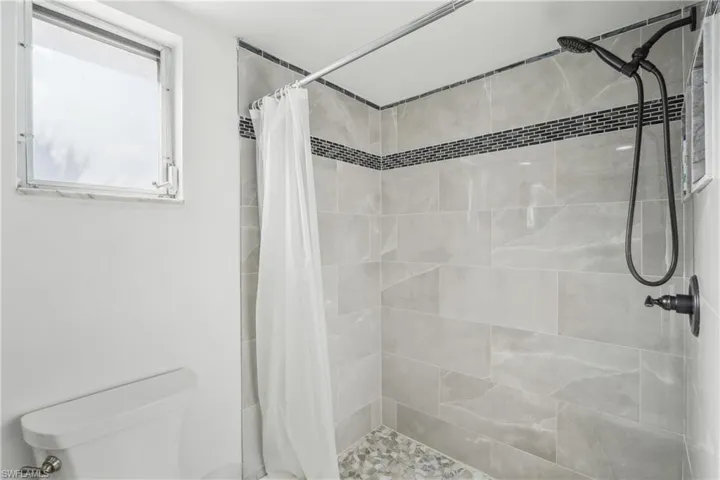 Bathroom featuring curtained shower and toilet