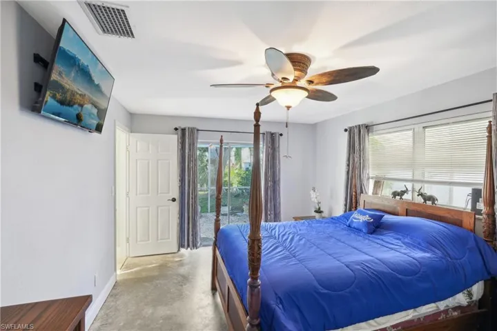 Bedroom with ceiling fan, access to exterior, and concrete flooring