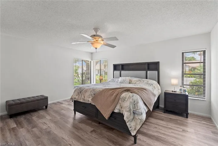 Bedroom with a textured ceiling, ceiling fan, and hardwood / wood-style floors