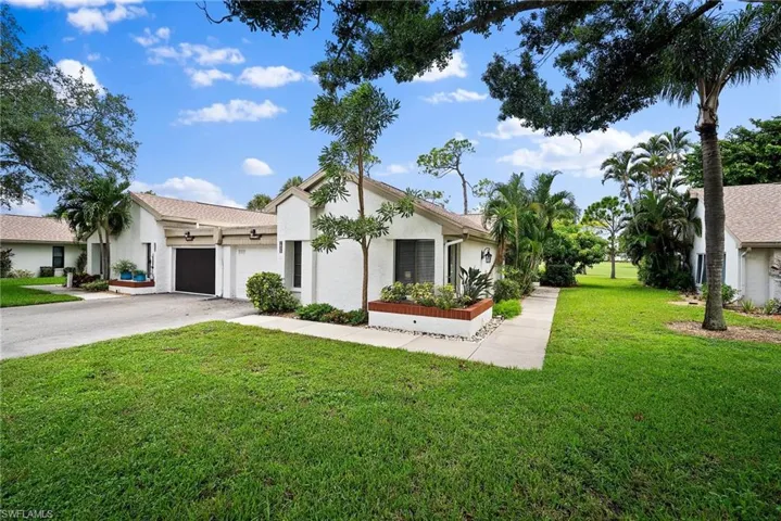View of front of home with a garage and a front lawn