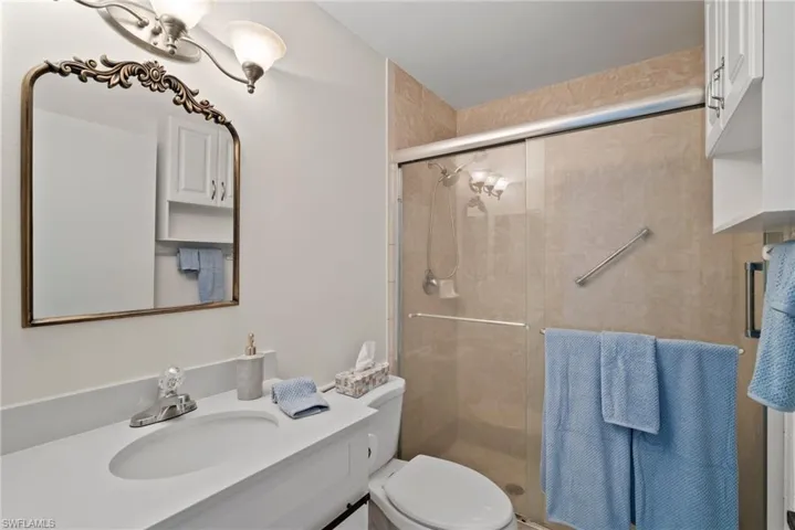 Bathroom featuring vanity, an enclosed shower, and toilet