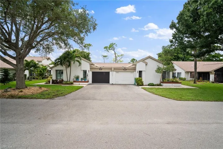 Single story home featuring a garage and a front yard