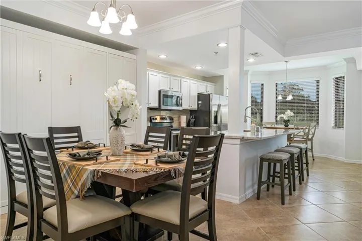 Dining room featuring light tile patterned floors, a chandelier, crown molding.