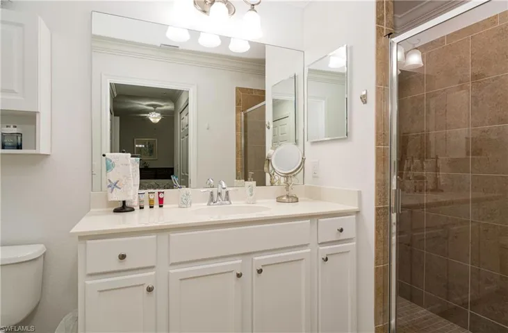 Primary bathroom featuring newly painted vanity, toilet, and walk in shower