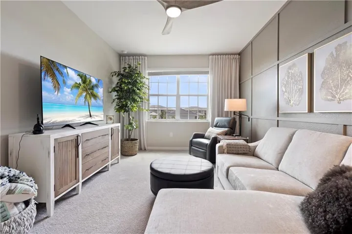 Living room featuring ceiling fan and light carpet