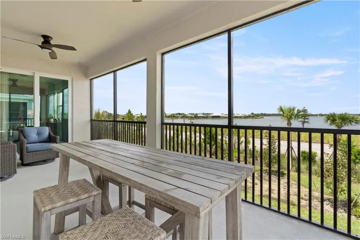 Sunroom / solarium featuring a water view and ceiling fan