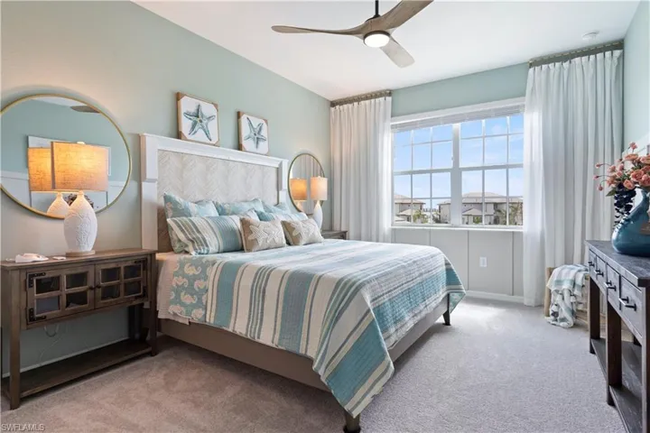 Carpeted bedroom featuring ceiling fan and baseboards